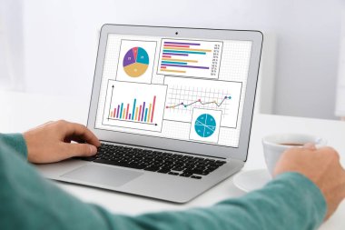 Değer kavramı. İçerideki masada dizüstü bilgisayarla çalışan adam, yakın plan.
