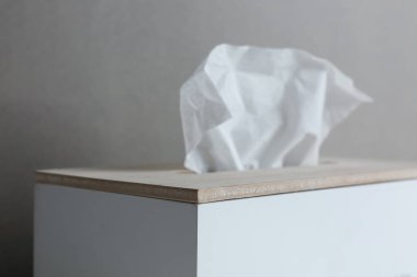 Gri arkaplanda kağıt mendilli tutucu, yakın plan