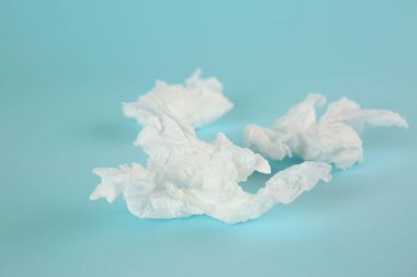 Açık mavi arkaplanda kullanılmış kağıt mendiller
