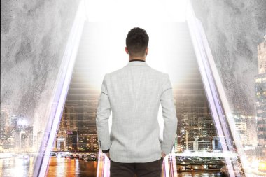 Merdivenlerin ve şehir manzarasının önünde iki kişi var. Başarıya giden yol