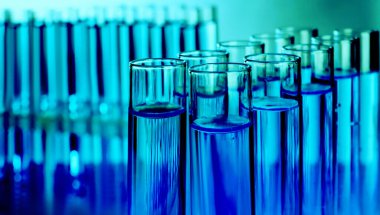 Sıvı içerikli test tüpleri bulanık arka planda, yakın plan. Laboratuvar analizi