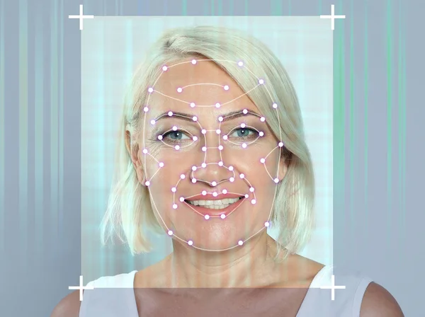 Facial recognition system. Mature woman with digital biometric grid frame on face