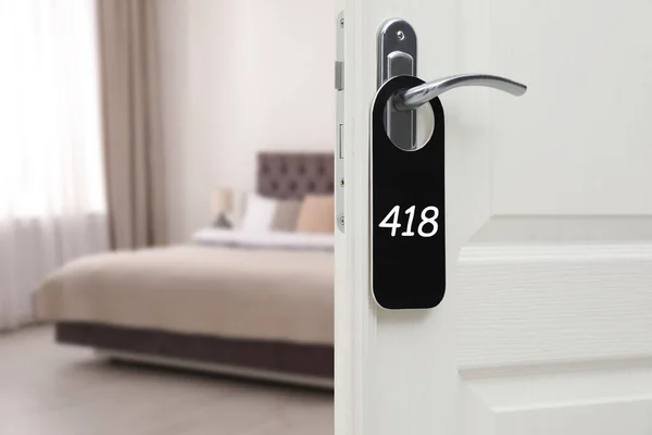 Open door with sign 418 on handle in hotel, closeup. Space for text