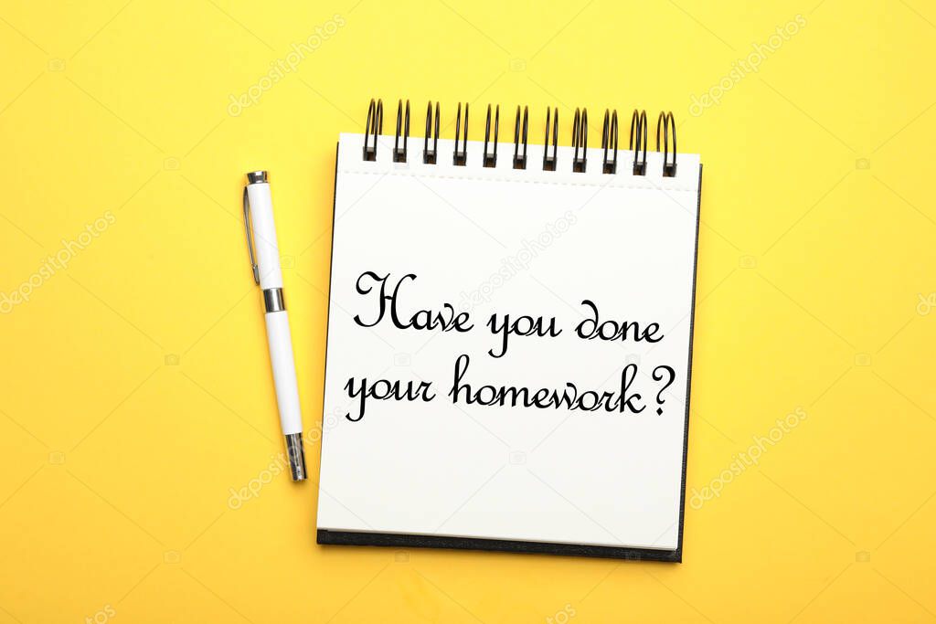 Pen and stylish notebook with phrase HAVE YOU DONE YOUR HOMEWORK? on yellow background, top view