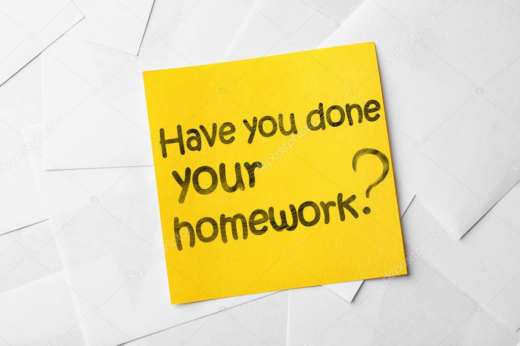 Note with phrase HAVE YOU DONE YOUR HOMEWORK? on paper sheets, top view 
