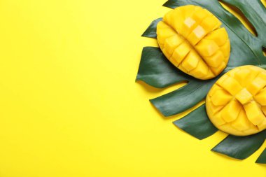 Taze olgun mango ve sarı arka planda yaprak kes, düz yat. Metin için boşluk