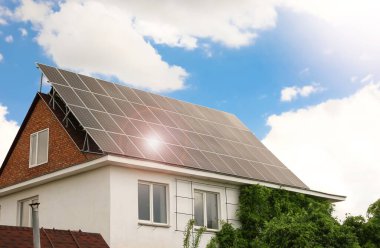 Çatıda kurulu güneş panelleri olan bir bina. Alternatif enerji kaynağı