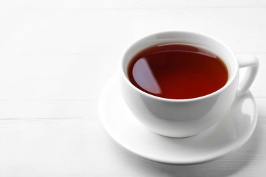 Beyaz ahşap masada bir fincan lezzetli siyah çay. Metin için boşluk