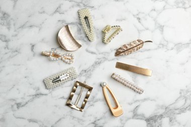 Beyaz mermer masada düz bir şekilde duran, şık saç tokalarının çerçevesi.