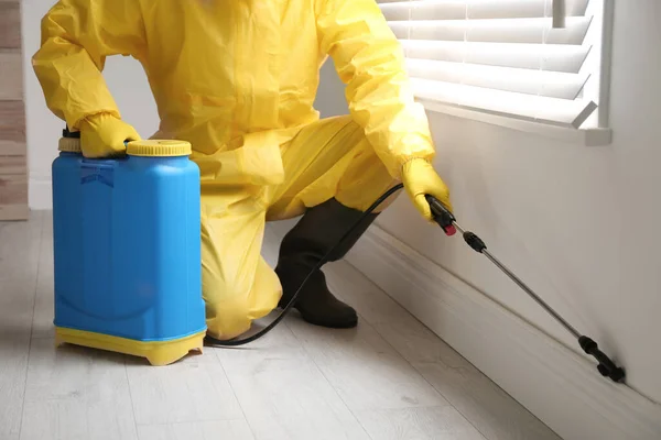 Trabajador Control Plagas Traje Protector Rociando Pesticida Cerca Ventana Interior —  Fotos de Stock