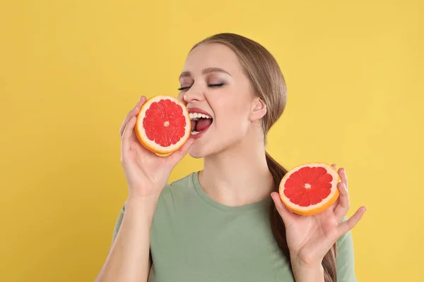 Mulher Jovem Emocional Com Toranja Cortada Fundo Amarelo Alimentos Ricos — Fotografia de Stock