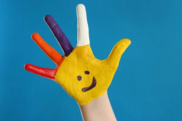 Kind Mit Lächelndem Gesicht Auf Handfläche Vor Blauem Hintergrund Nahaufnahme — Stockfoto