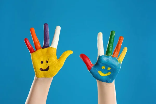 Kind Mit Lächelnden Gesichtern Auf Handflächen Vor Blauem Hintergrund Nahaufnahme — Stockfoto