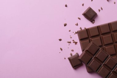 Pembe arka planda lezzetli sütlü çikolata, düz yatak. Metin için boşluk