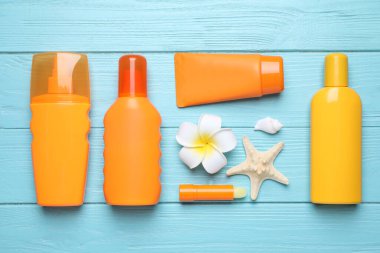 Açık mavi ahşap zemin üzerinde güneş koruma ürünleri, düz yatıyordu