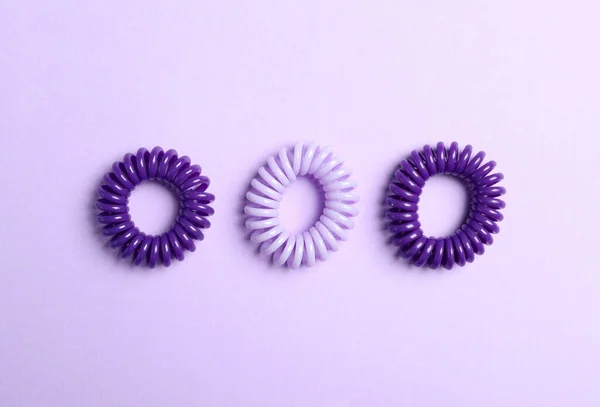 Stylowe Gumki Spiralne Fioletowym Tle Płaskie — Zdjęcie stockowe