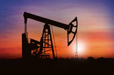 Gün batımında ham petrol pompasının silueti