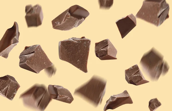 Deliciosas Piezas Chocolate Cayendo Sobre Fondo Amarillo — Foto de Stock