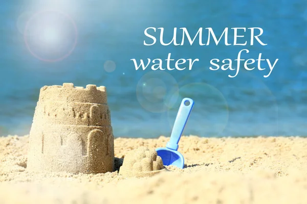 Summer water safety. Beautiful view of beach with sand figure and shovel near sea
