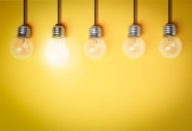 Fikir konsepti. Sarı arkaplanda ampuller, metin için boşluk 