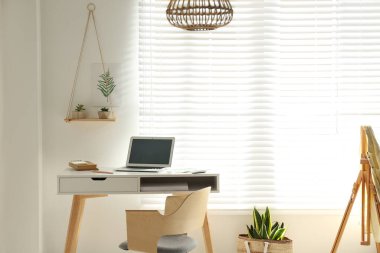 Pencerenin yanında işyeri olan şık bir oda.