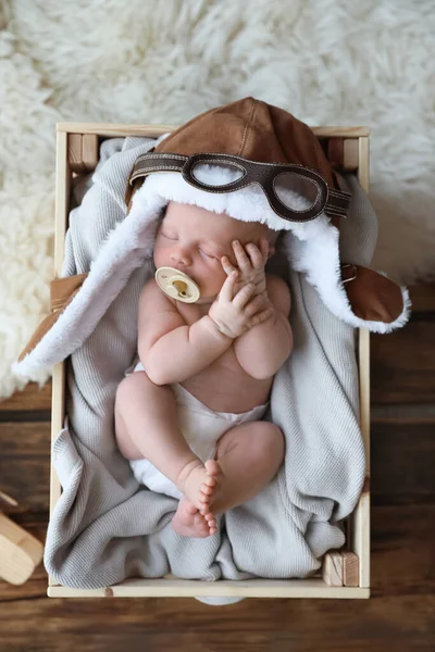 Sød Nyfødt Baby Iført Aviator Hat Med Legetøj Sover Trækasse - Stock-foto