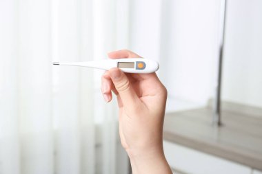 Modern dijital termometresi olan kadın, yakın plan.