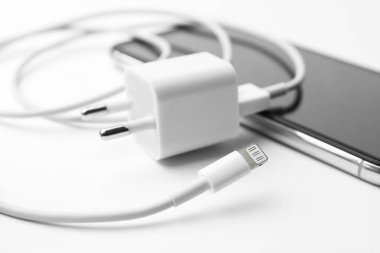 Akıllı telefon ve kabloyu beyaz arkaplanda adaptörle şarj et, kapat