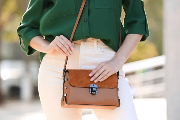 Young woman with stylish leather bag outdoors on summer day, closeup