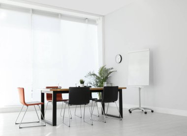 Büyük masası ve sandalyeleri olan basit bir ofis.