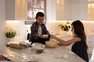 Sevimli küçük çocuklar mutfakta hamur pişiriyor.