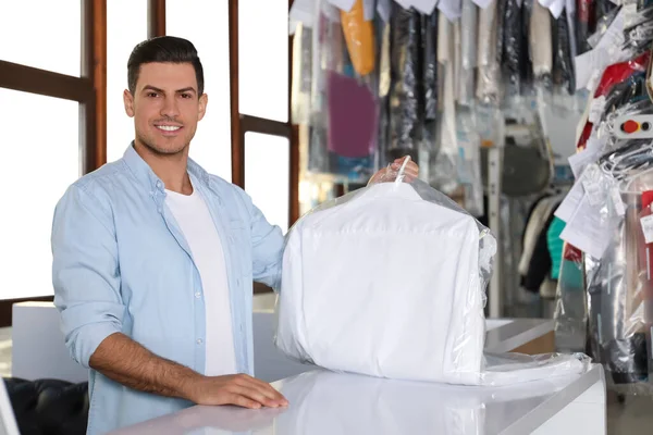 Happy client with shirt at modern dry-cleaner\'s