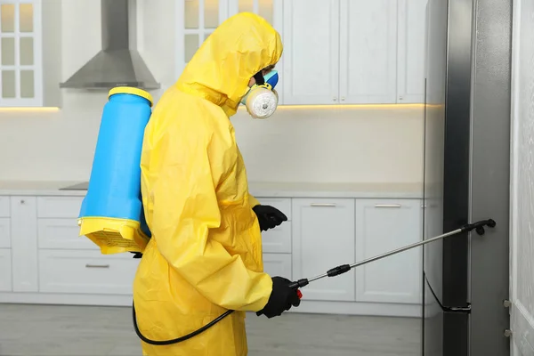 Trabajador Control Plagas Traje Protector Rociando Insecticida Cerca Del Refrigerador —  Fotos de Stock