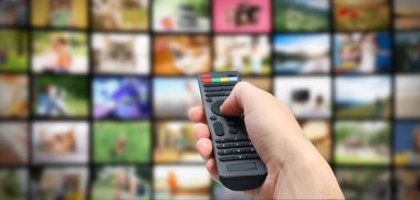 Yayınlanan video servisleri. TV 'de kanal değiştirmek için uzaktan kumanda kullanan adam, kapat