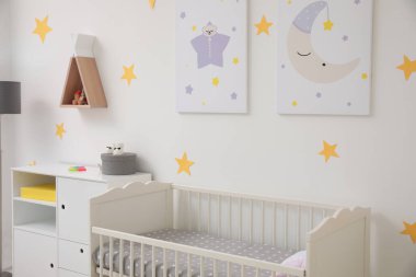 Beşik ve dekorasyon elementleri olan şık bir bebek odası.