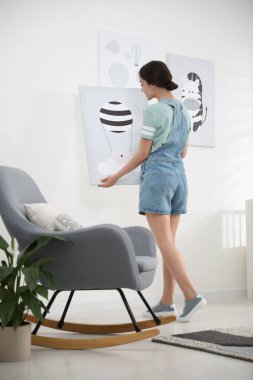 Beyaz duvarın yanında resmi olan bir dekoratör. Çocuk odası iç tasarımı.