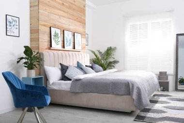 Geniş rahat yatak ve güzel tablolarla süslü bir oda.