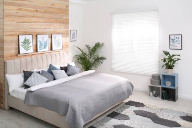 Geniş rahat yatak ve güzel tablolarla süslü bir oda.