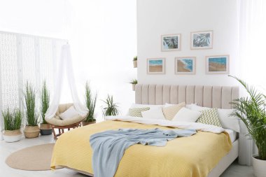 Geniş rahat yatak ve güzel tablolarla süslü bir oda.