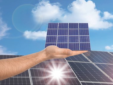 Güneş panelini açık havada gösteren bir adam, yakın plan. Alternatif enerji kaynağı 