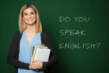 Yeşil yazı tahtasının yanındaki güzel öğretmen İngilizce biliyor musun?