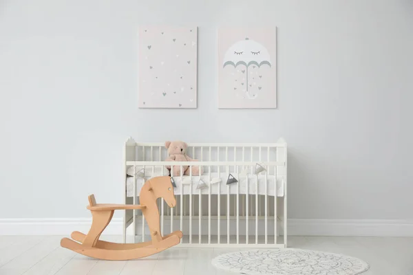 Minimalist room interior with baby crib, decor elements and toys