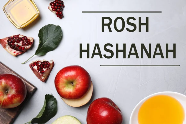 Honey, apples and pomegranate on light table, flat lay. Rosh Hashanah holiday