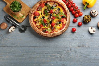 Açık gri ahşap masada sebze pizzalı düz kompozisyon. Metin için boşluk