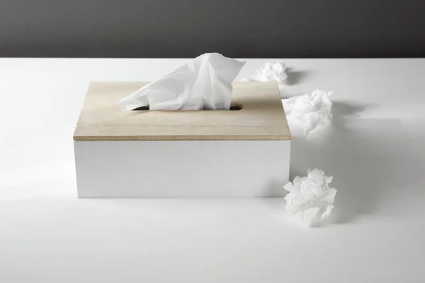 Used paper tissues and holder on white table