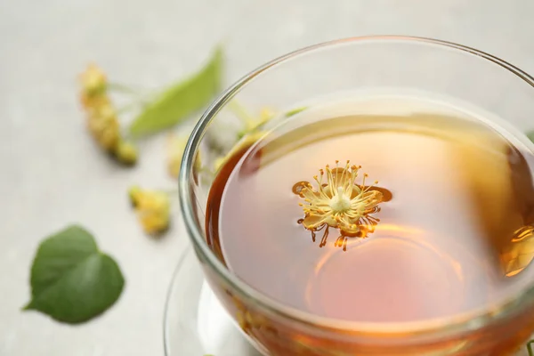 テーブルの上にリンデンの花とお茶のカップ クローズアップ — ストック写真