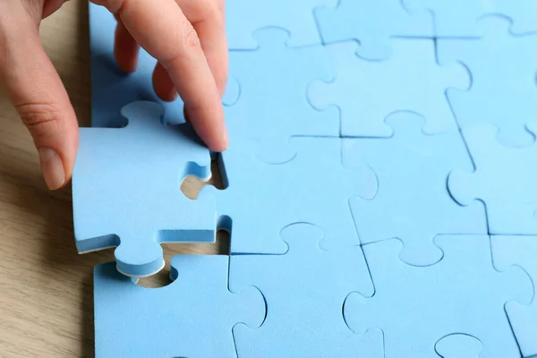 Woman putting light blue puzzle piece, closeup with space for text. Career promotion concept