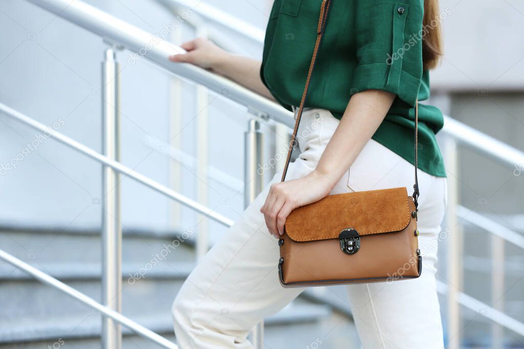 Young woman with stylish leather bag outdoors on summer day, closeup