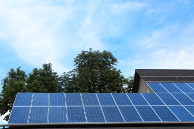 Çatıda kurulu güneş panelleri olan bir bina. Alternatif enerji kaynağı