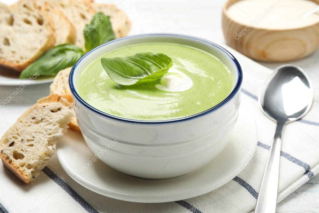 Tasty homemade zucchini cream soup served on table